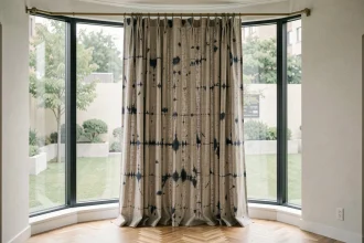 Rideaux japonisant sur mesure en lin naturel avec motif shibori indigo devant une large baie vitrée panoramique